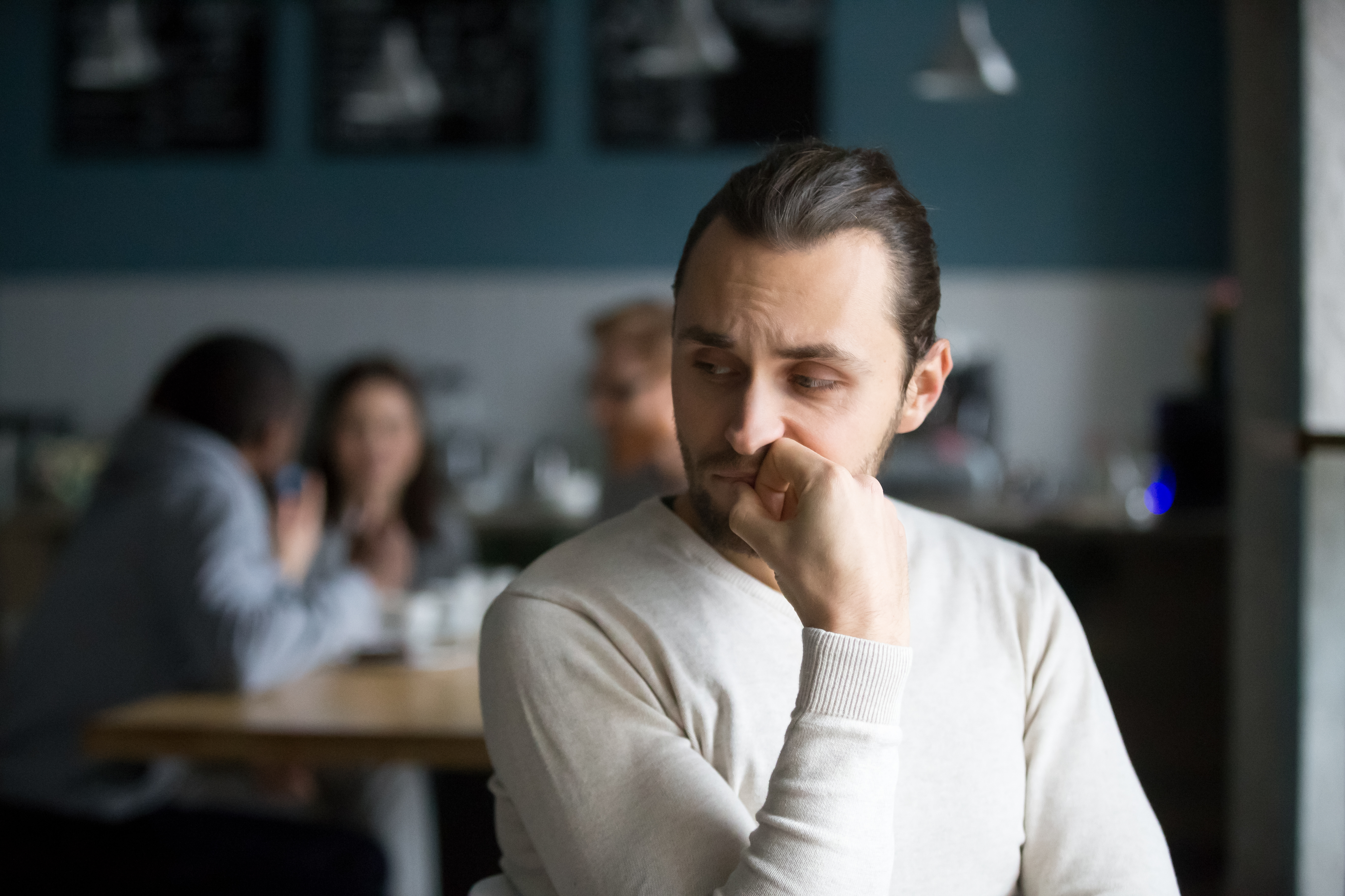 A young man sitting alone in a restaurant | Source: Shutterstock