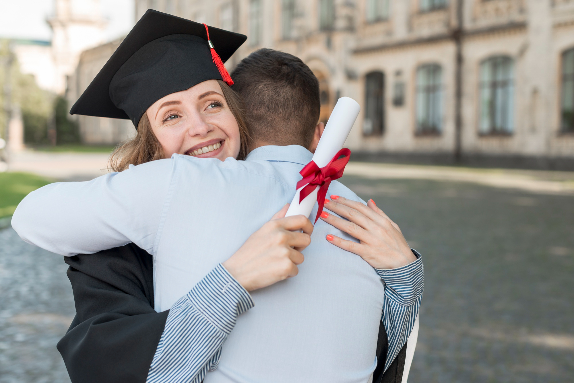 A happy female college graduate being embraced by a man | Source: Pexels