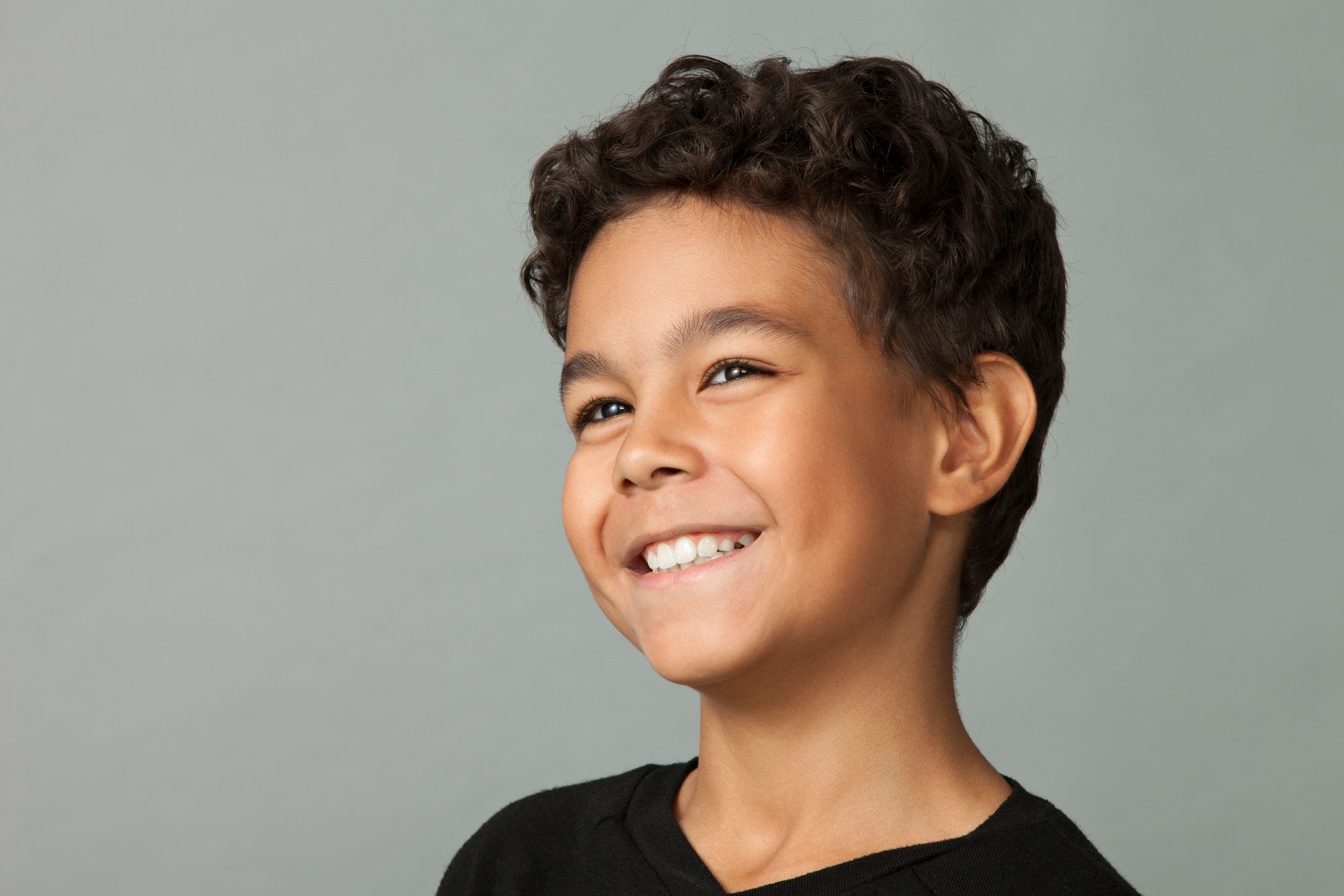 Closeup studio portrait of a 12 year old boy on gray background | Source: Getty Images