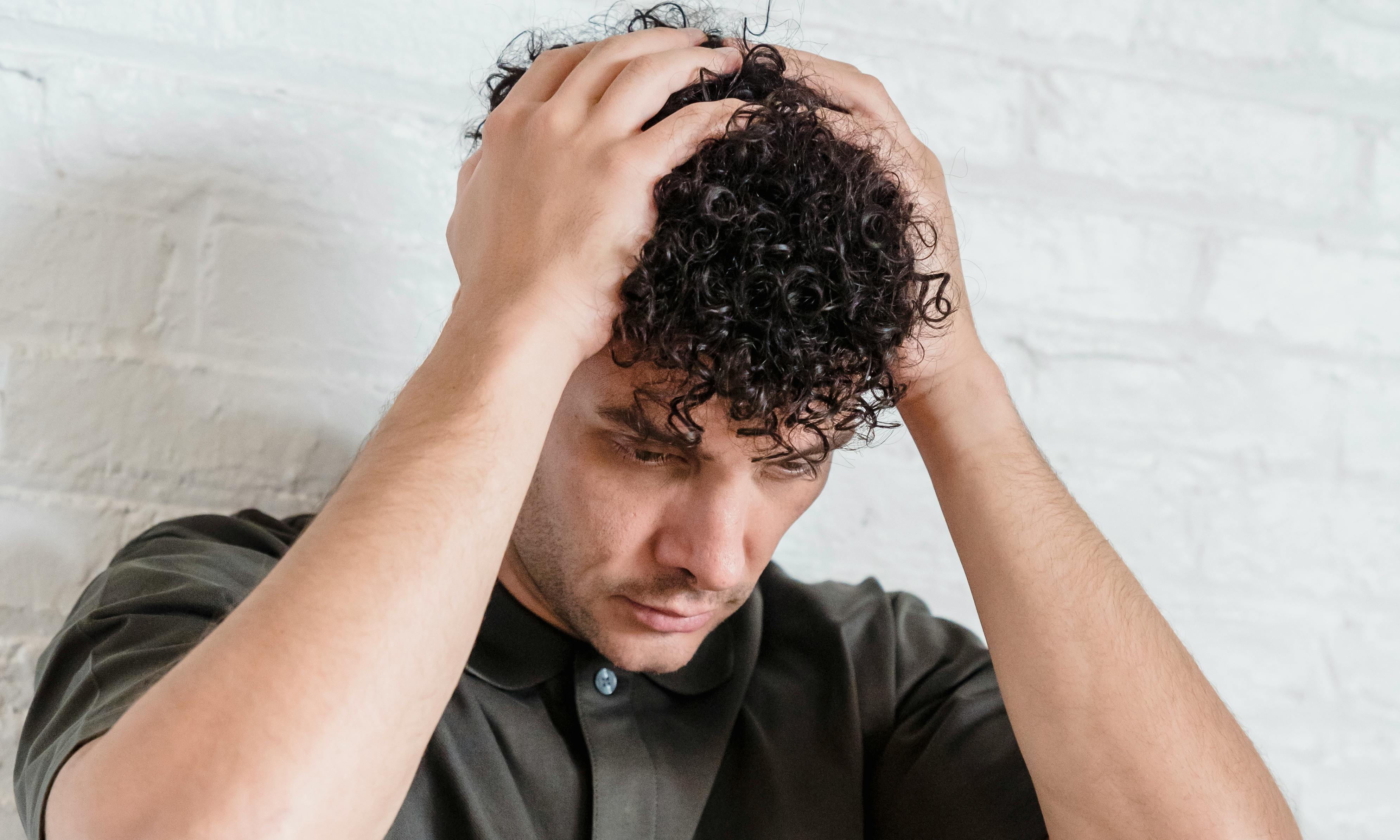 A man holding his head in his hands | Source: Pexels