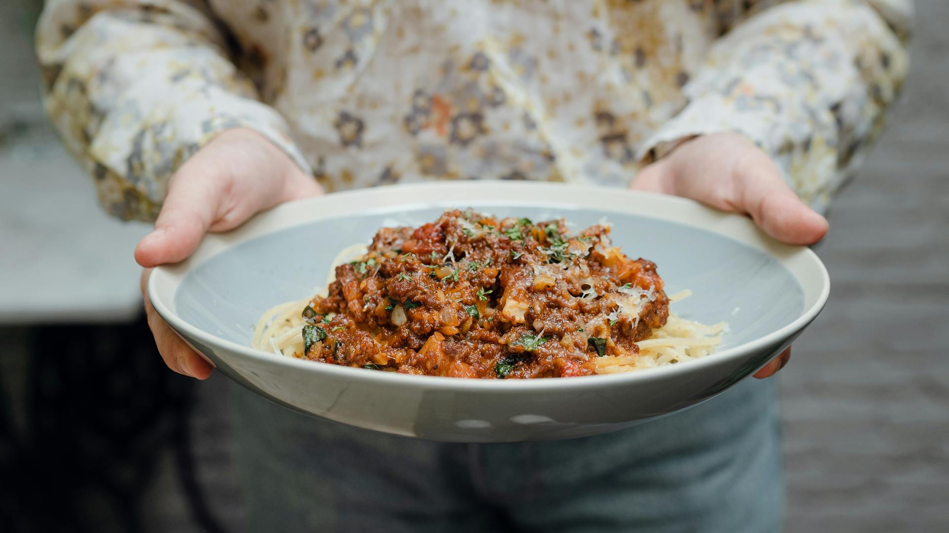 A close-up shot of a young woman holding a plate of pasta | Source: Pexels