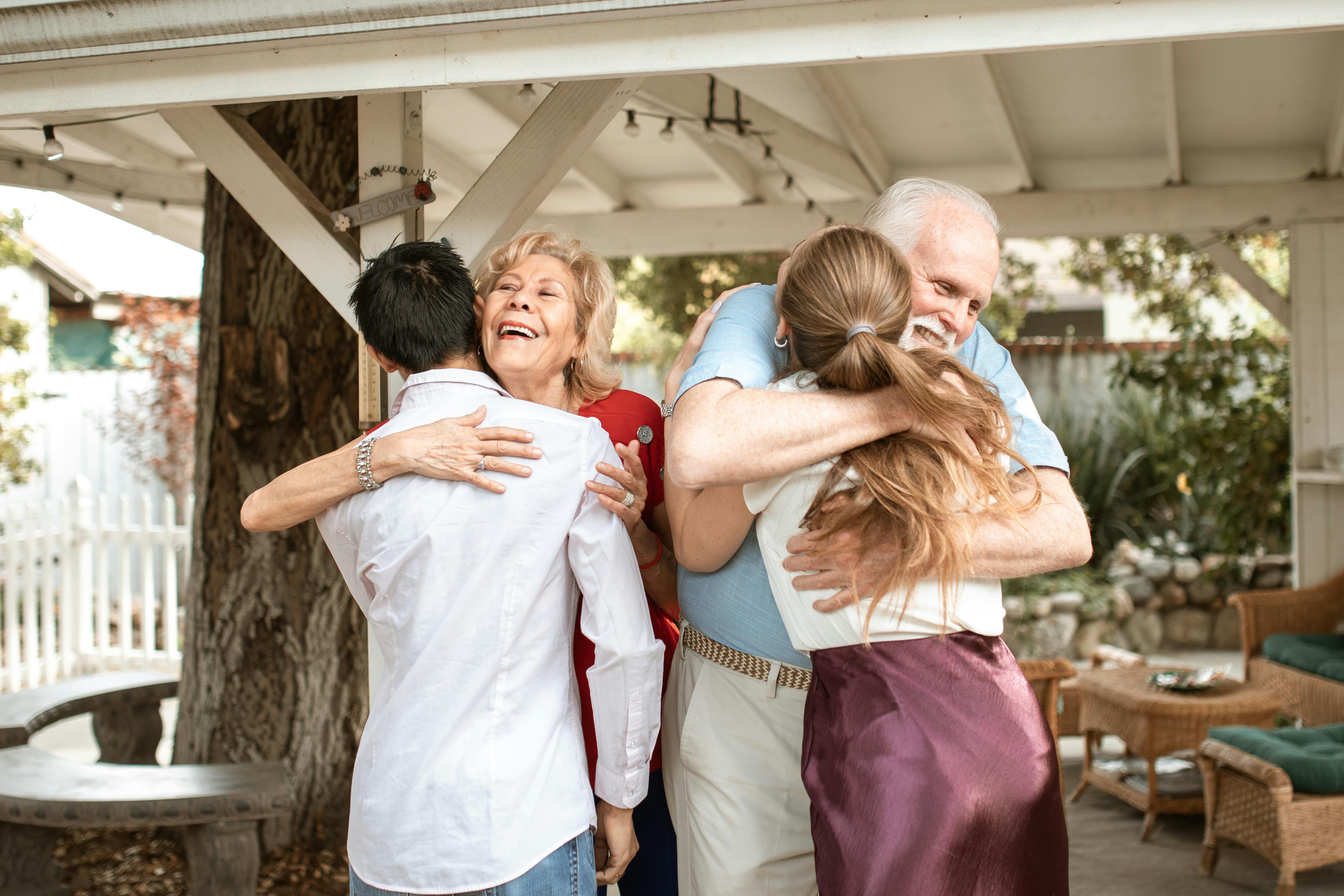 A senior couple hugging their children | Source: Pexels