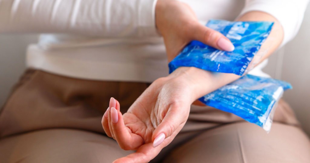 Close up of woman applying cold compress to a her painful wrist