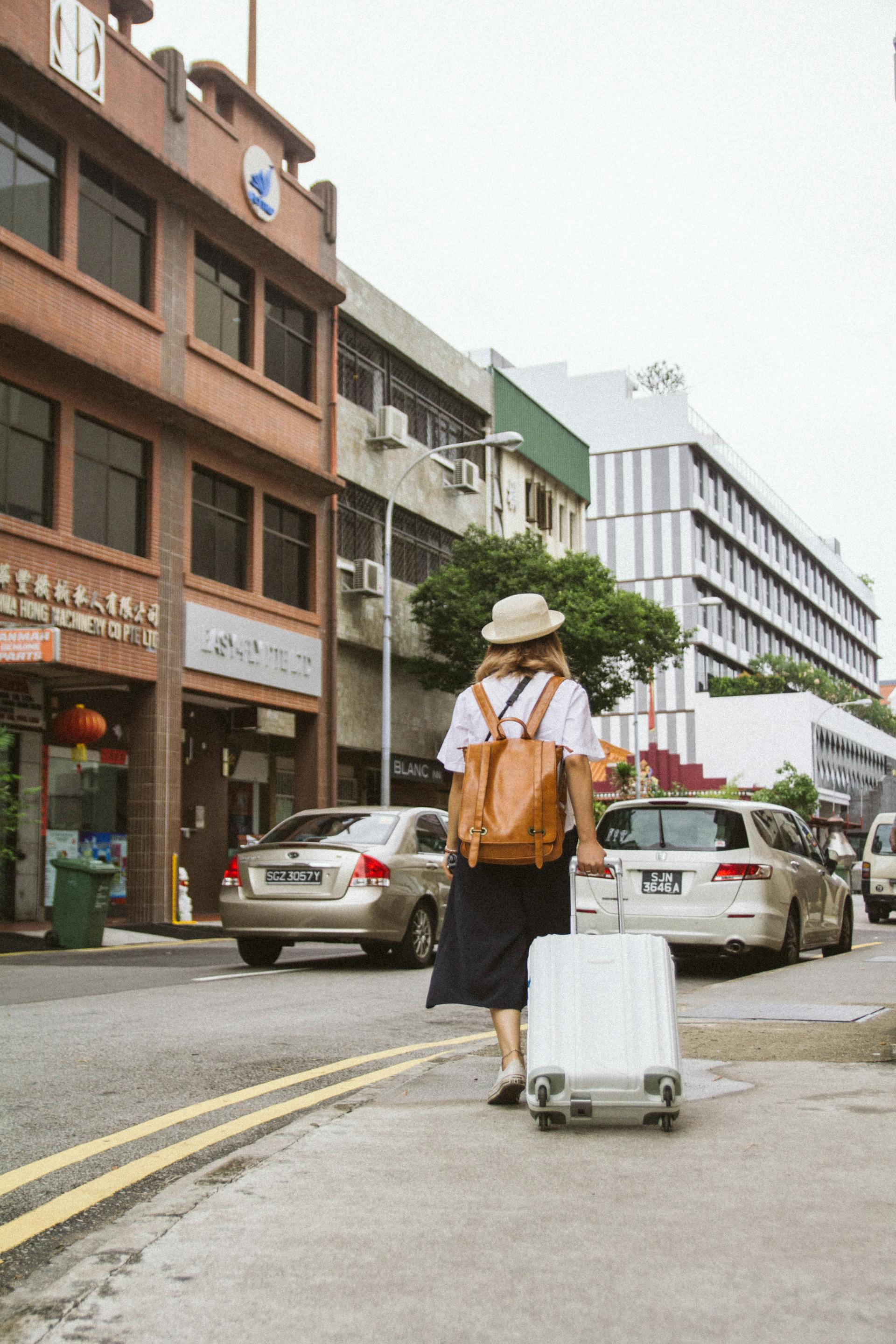 A woman walking away with her suitcase | Source: Pexels