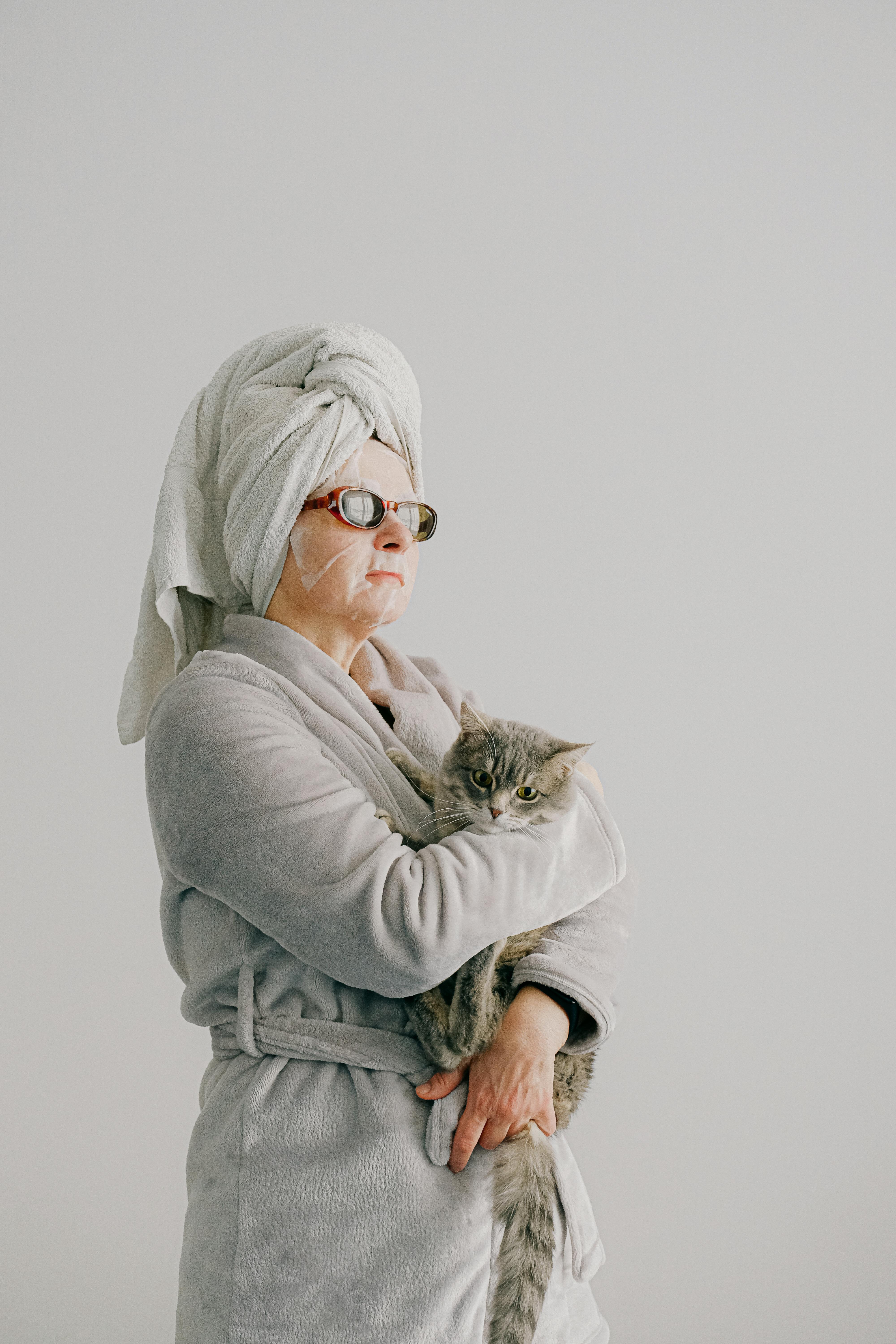 An arrogant woman dressed in a gown, and sunglasses while holding a cat | Source: Pexels