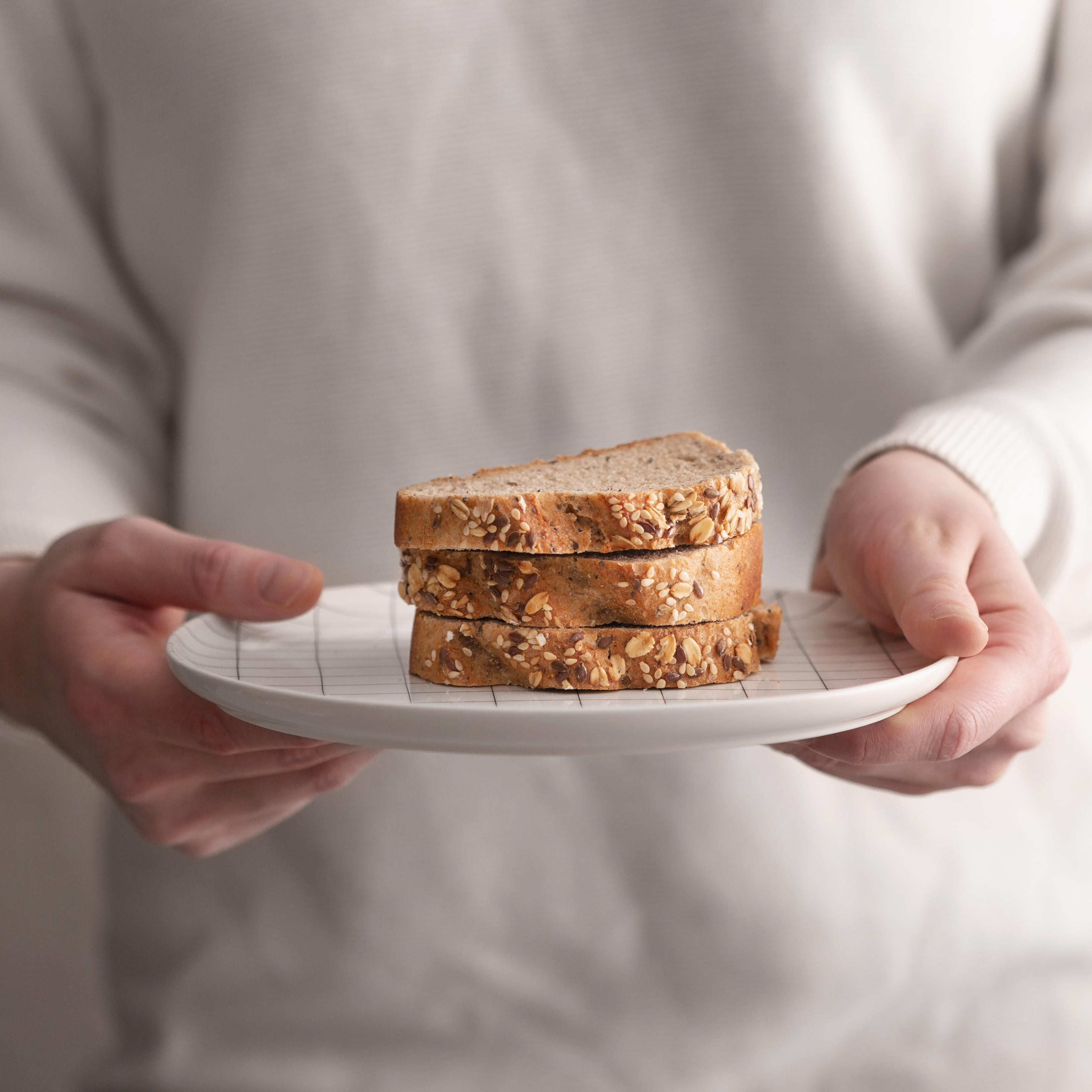 Man holding a plate of banana bread | Source: Freepik